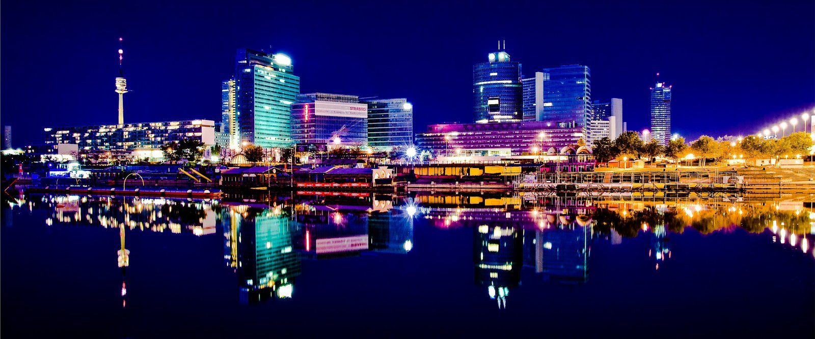 Illuminated city skyline reflected in water at night